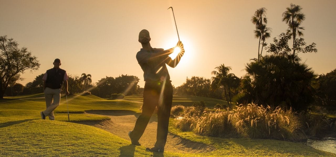 Sunset behind a man golfing at Boca West Country Club