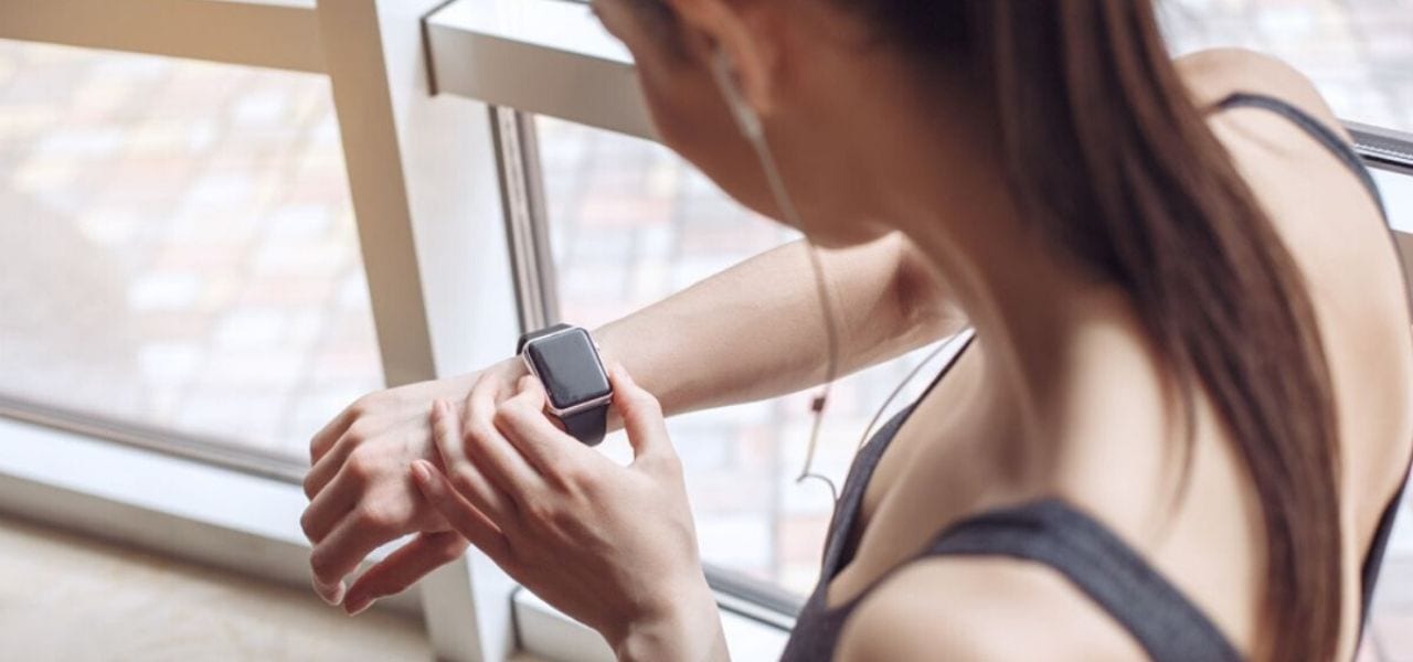 Woman Looking Down at Her Watch Getting Ready to Work Out
