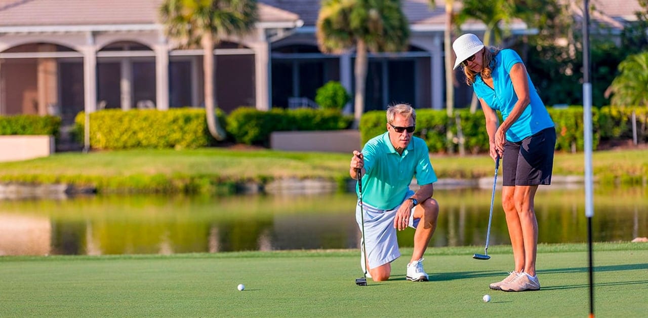 Lady and man hitting golf ball into hole