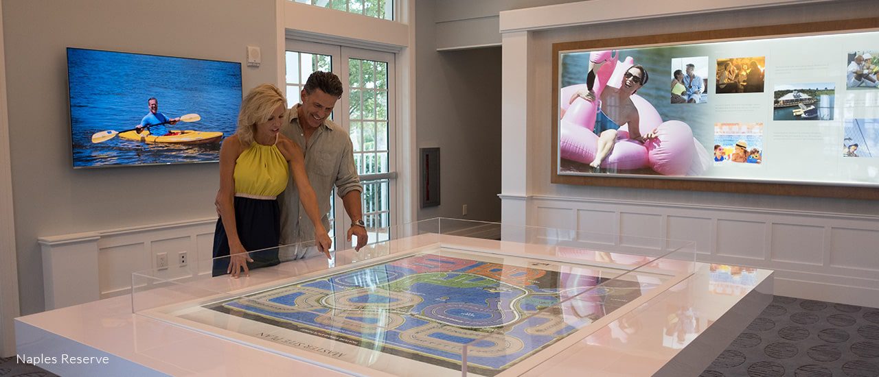 couple in naples reserve sales office looking at community model