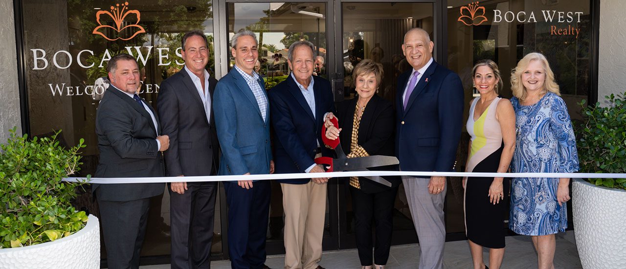 boca west realty team at ribbon cutting for opening sales center
